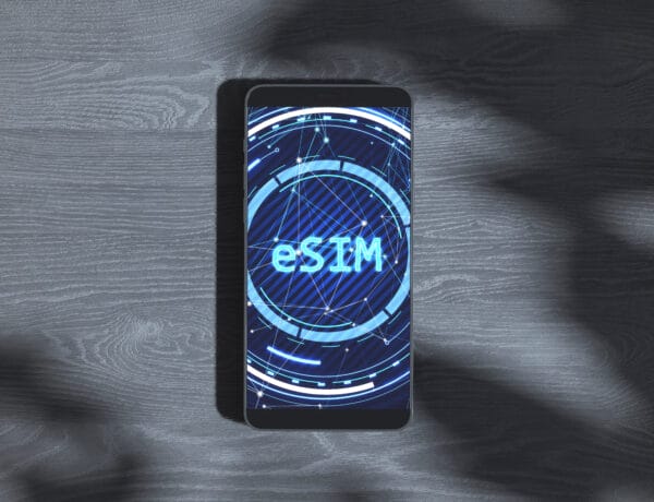 Smartphone displaying "eSIM" with tech inspired graphics on a wooden background, highlighting the concept of creative digital solutions. 3D Rendering